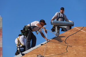 Roofer installing different layers of roof